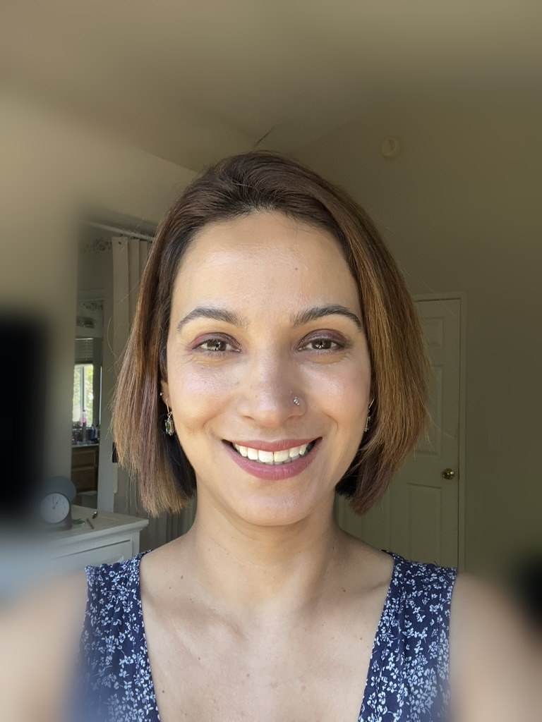 Sumeet Bodington smiling in a navy patterned top
